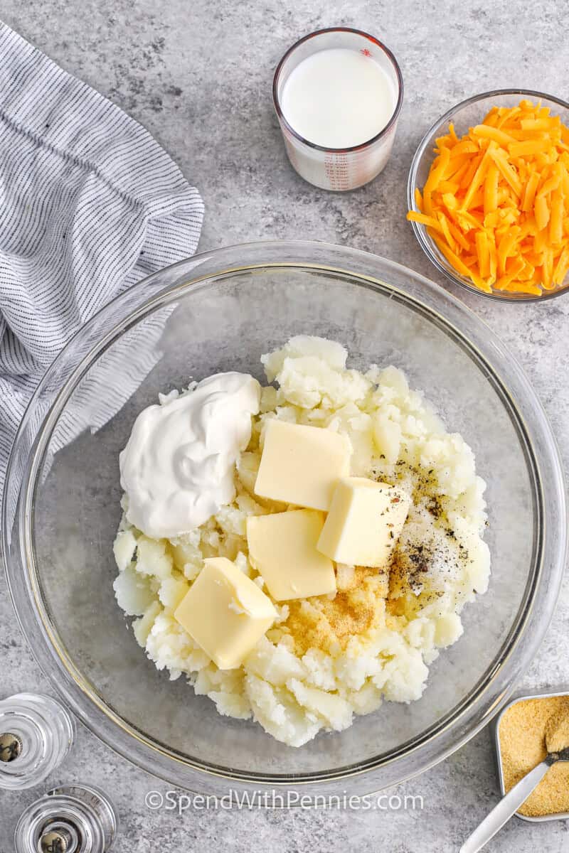 adding ingredients to potatoes in bowl to make Twice Baked Potatoes