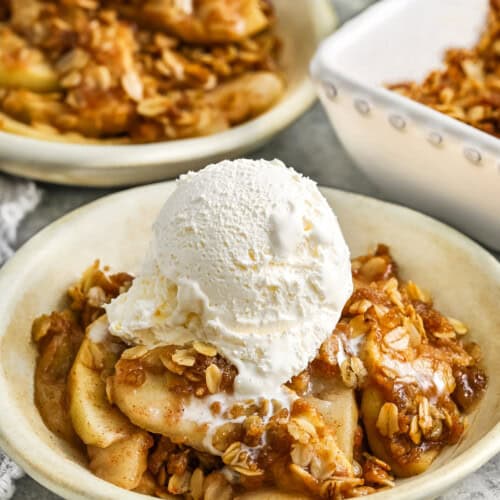 plated dishes of Apple Crisp Recipe with ice cream scoop on top