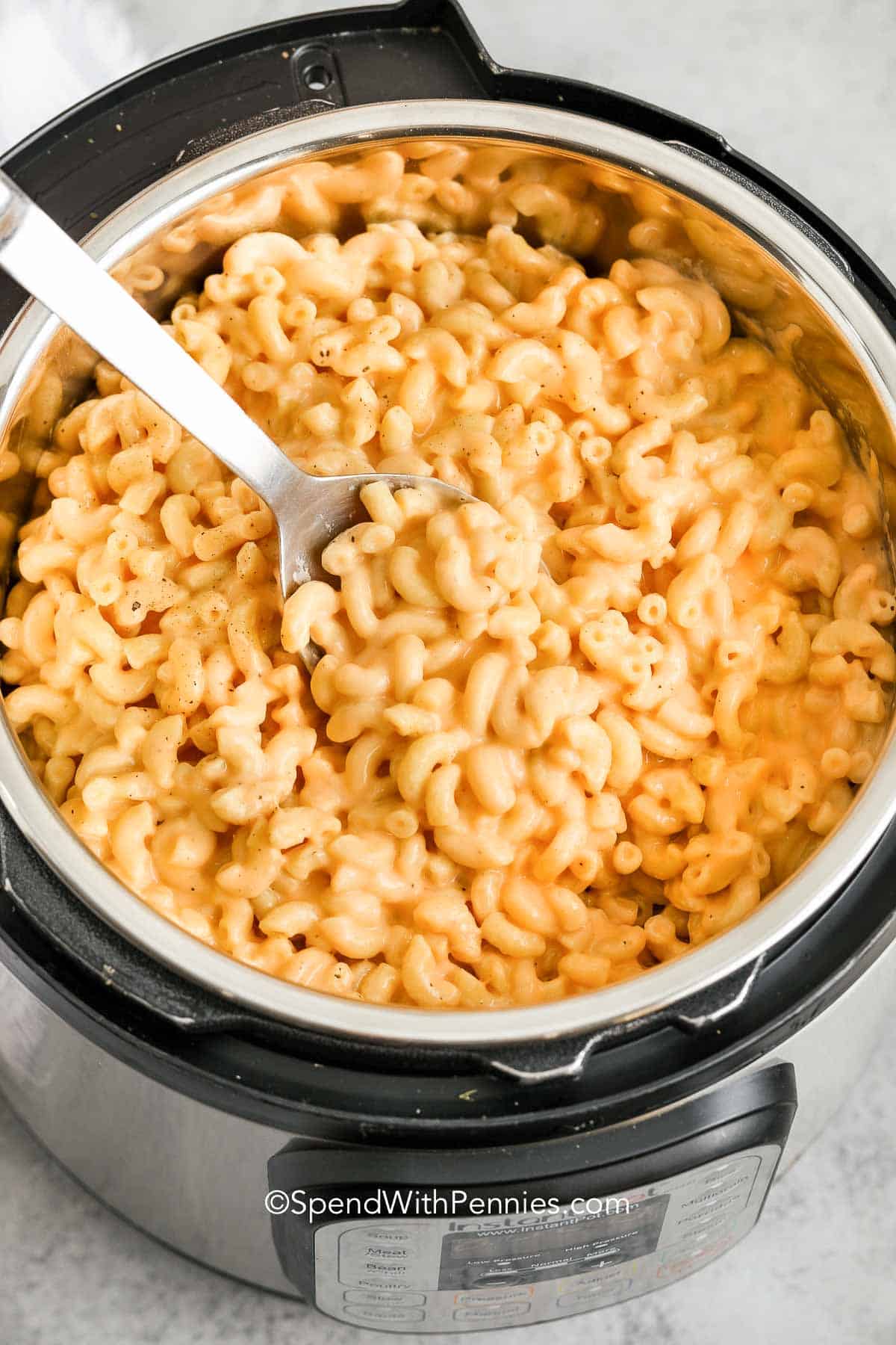 instant pot mac and cheese being being served with a spoon