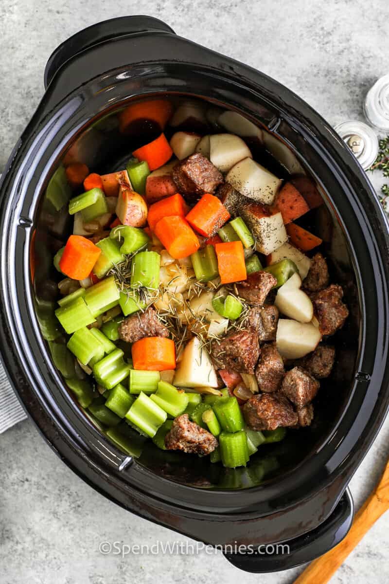 adding ingredients to pot to make Crock Pot Beef Stew