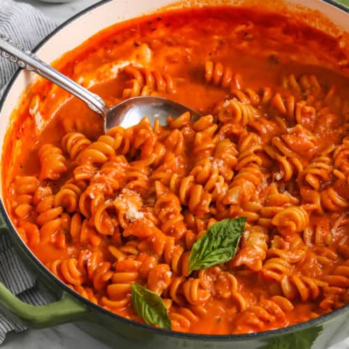 close up of One Pot Pasta in a green pot with a spoon