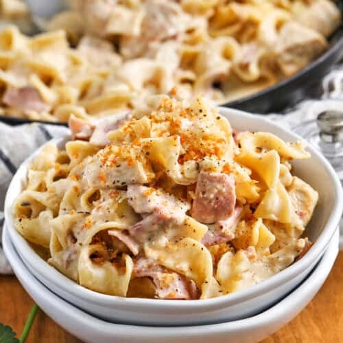 chicken cordon bleu in a white bowl with a crispy parmesan topping