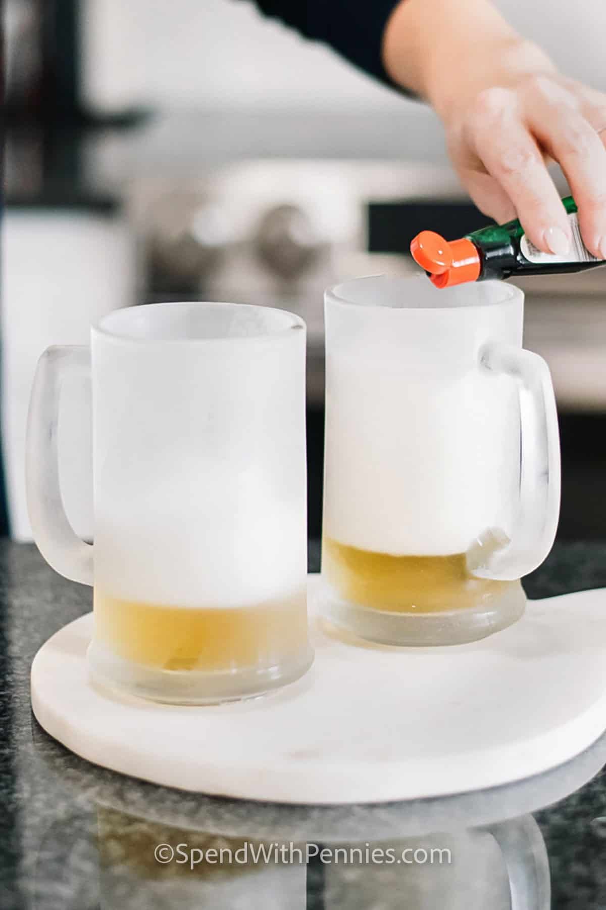 adding drops of food coloring to two pints of green beer for how to make green beer recipe.