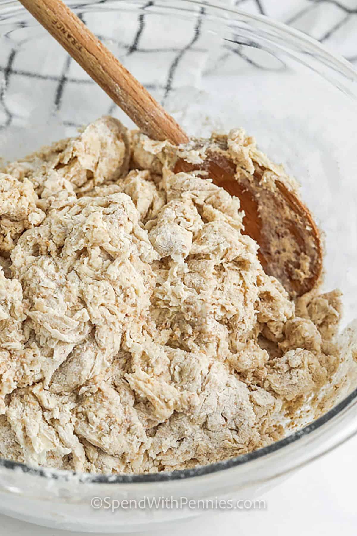 Irish soda bread batter in a glass bowl with a wooden spoon
