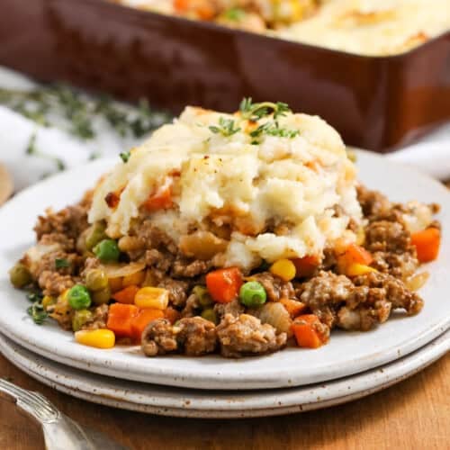 Shepherd's Pie in a plate and dish full in the background