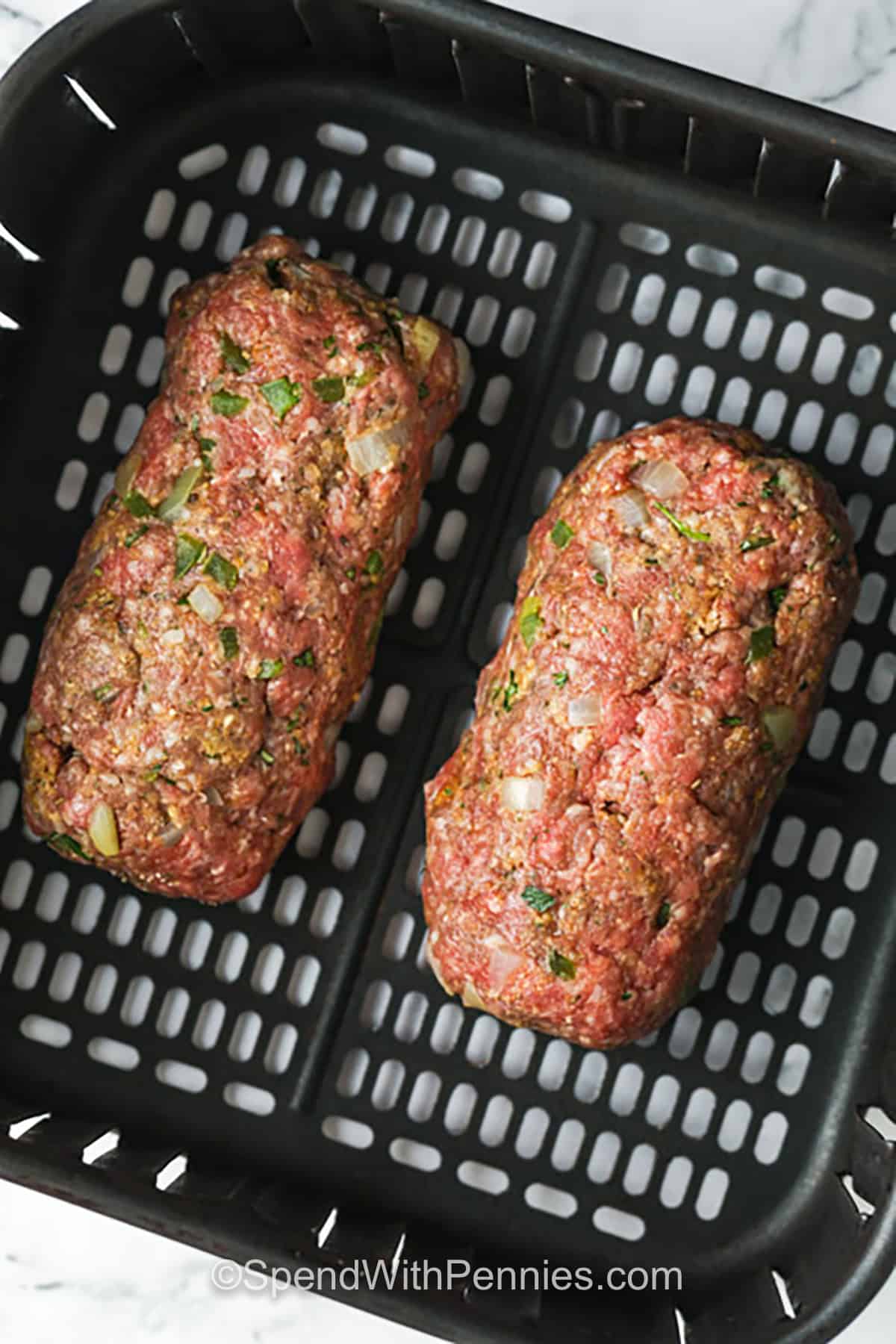 This air fryer meatloaf is a quick, hassle-free way to make a comforting family meal. Made with lean ground beef, bell pepper, onion, and seasonings, these mini meatloafs are perfectly tender inside and crispy on the outside. A tangy tomato and chili sauce topping completes the dish, adding a flavorful finish. Ready in just 30 minutes, this simple recipe is a must-try. #spendwithpennies meatloaf in the air fryer to make Air Fryer Meatloaf