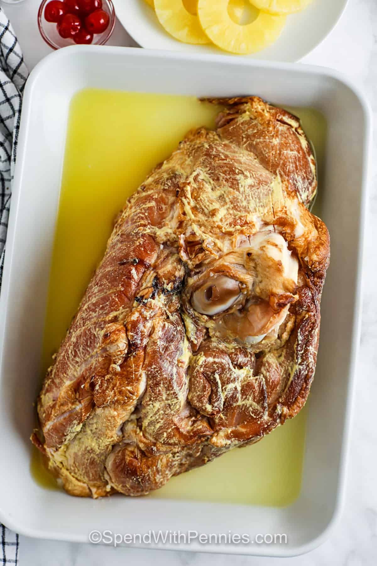 ham in a dish with glaze to make Pineapple Glazed Ham