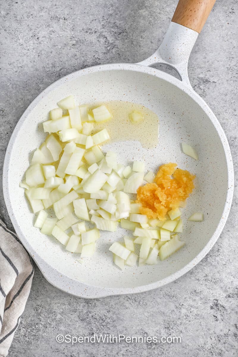 cooking garlic and oil with onions to make Slow Cooker Chicken Stew