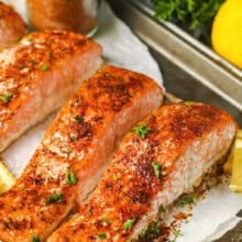 salmon cooked on a sheet pan with a jar of Salmon Seasoning