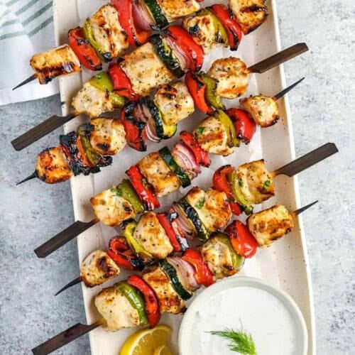 Greek Chicken Kabobs on a plate with dip