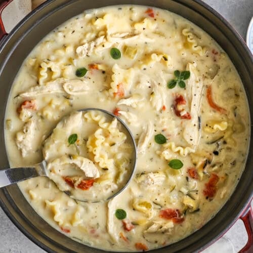 Dutch oven full of white lasagna soup with a ladle