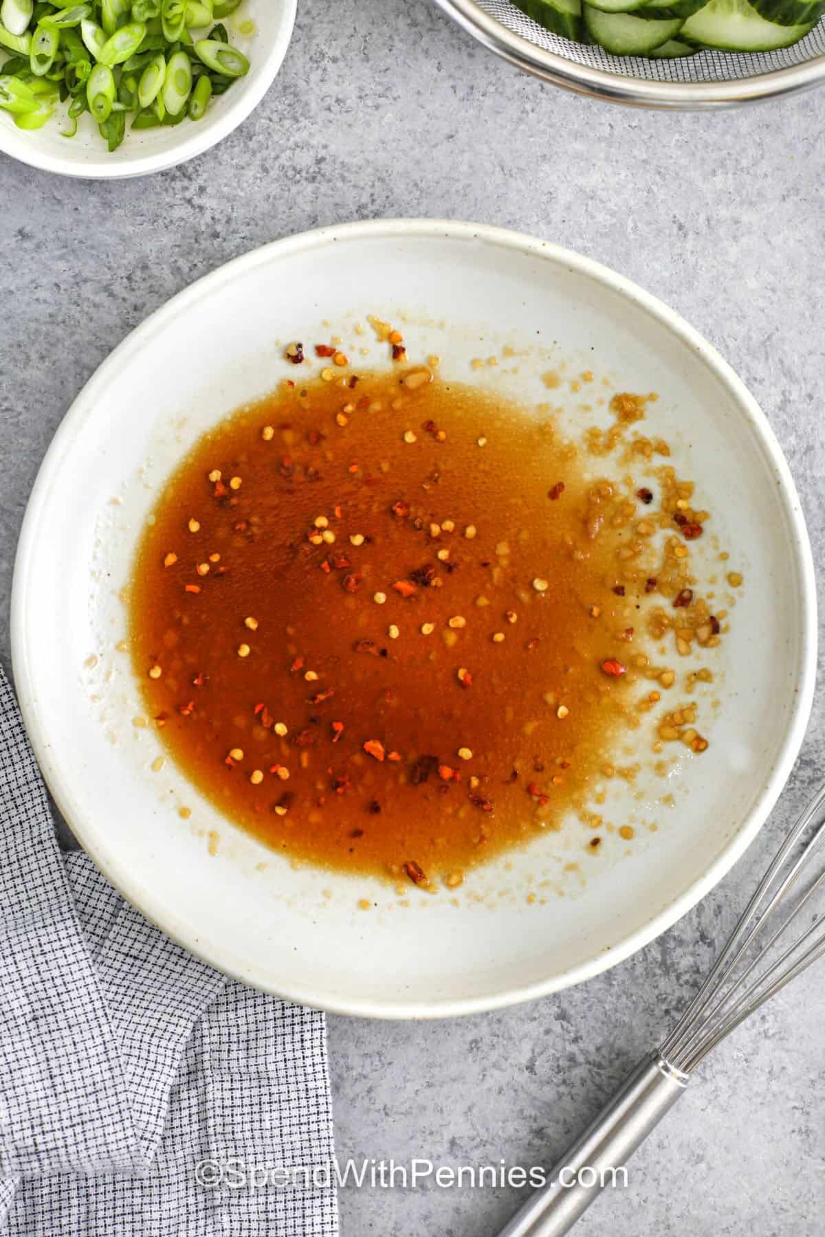 dressing for asian cucumber salad in a white bowl