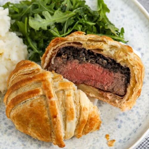 Beef Wellington sliced in half on a plate
