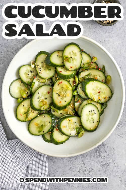 asian cucumber salad in a white bowl with writing