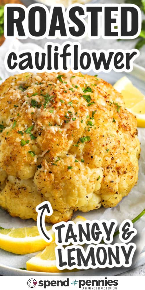 whole roasted cauliflower on a platter with lemon slices, with writing