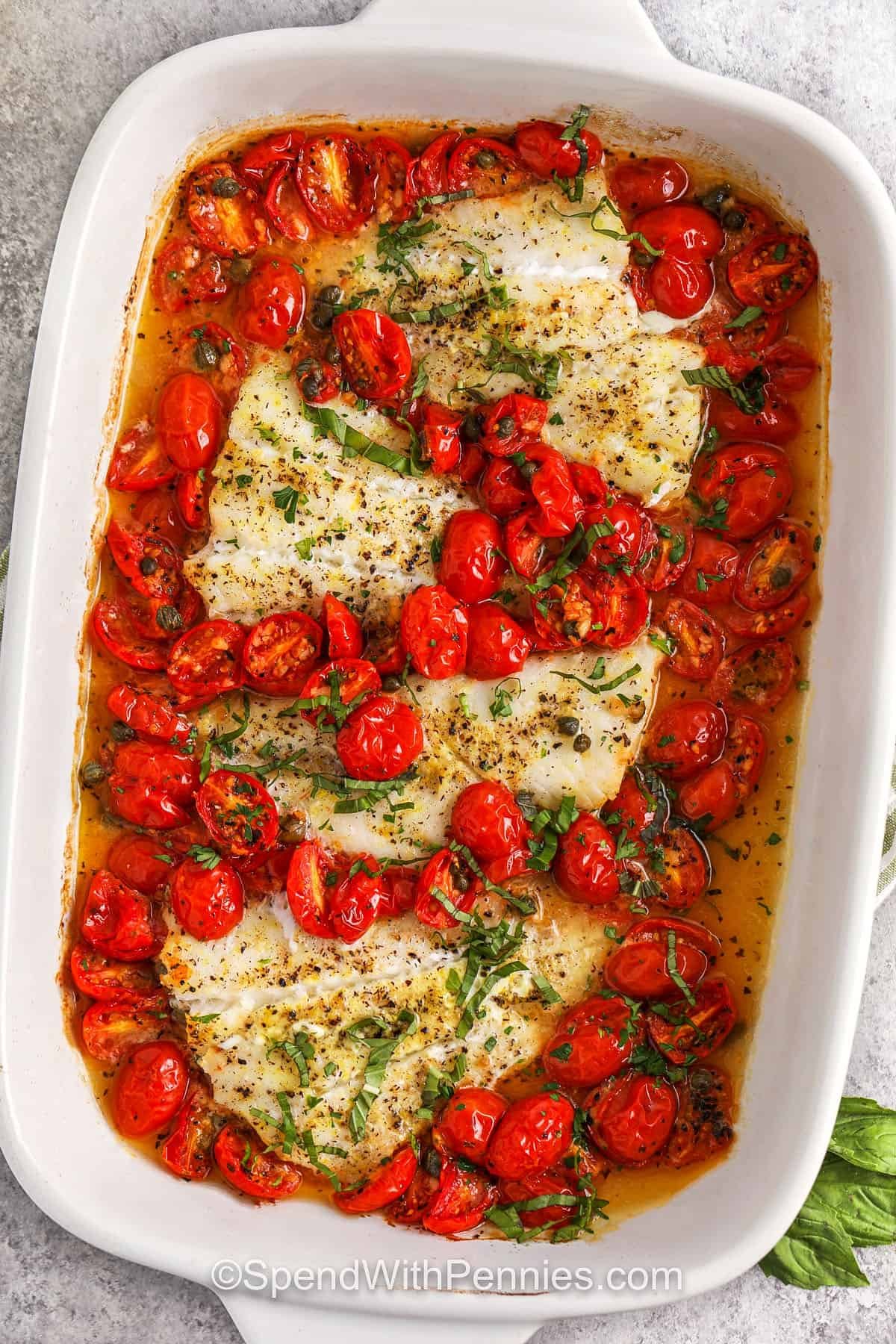 Roasted cod with tomatoes offers big flavor with minimal energy and cleaning! Juicy cherry tomatoes grilled with flaky cod, with garlic, capers and lemon seasoning for added umami beauty. The quick drizzle of butter tied everything together to make a rich but still light dish. This simple plate meal is perfect for busy weekdays or relaxing weekend dinners. #spendwithpennies Grilled cod with tomatoes in casserole