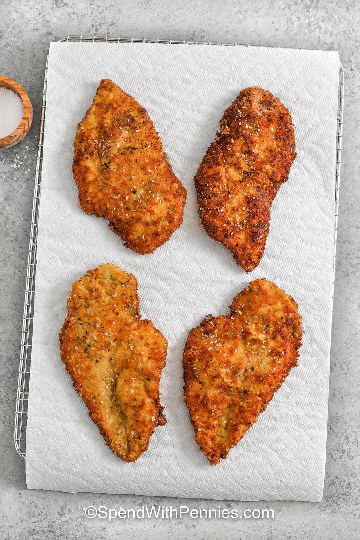 Chicken Milanese on a cooling rack with paper towel
