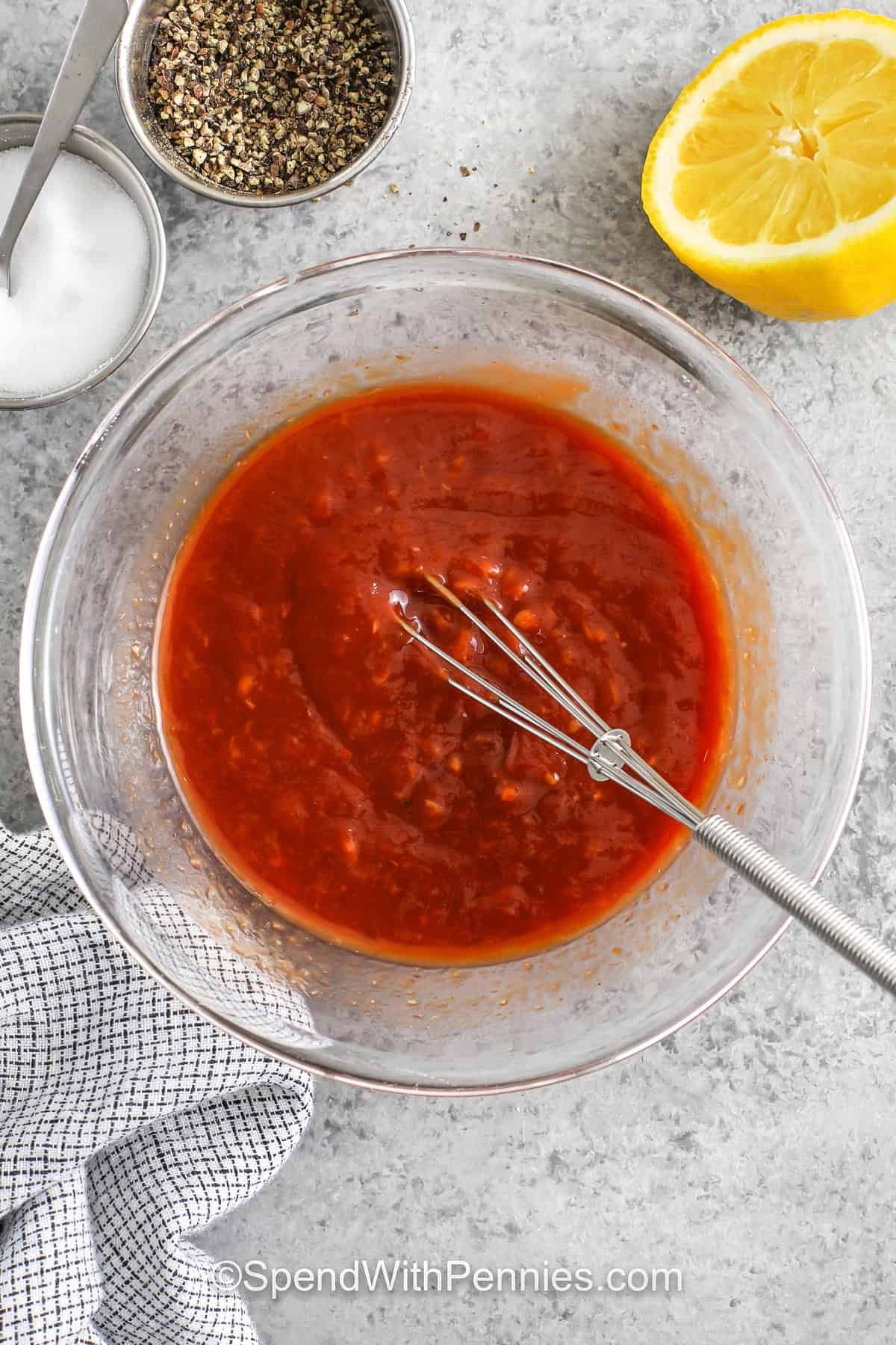 This easy cocktail sauce recipe is a quick and flavorful addition to any seafood platter, ready in just minutes. The base of ketchup and horseradish gives it a sweet and spicy kick, while lemon juice adds a bright, fresh flavor. A little Worcestershire sauce and simple seasonings take it over the top. Chill for 30 minutes to let those bold flavors blend beautifully. Perfect for entertaining or a simple weeknight dinner. #spendwithpennies mixing Cocktail Sauce ingredients in a bowl