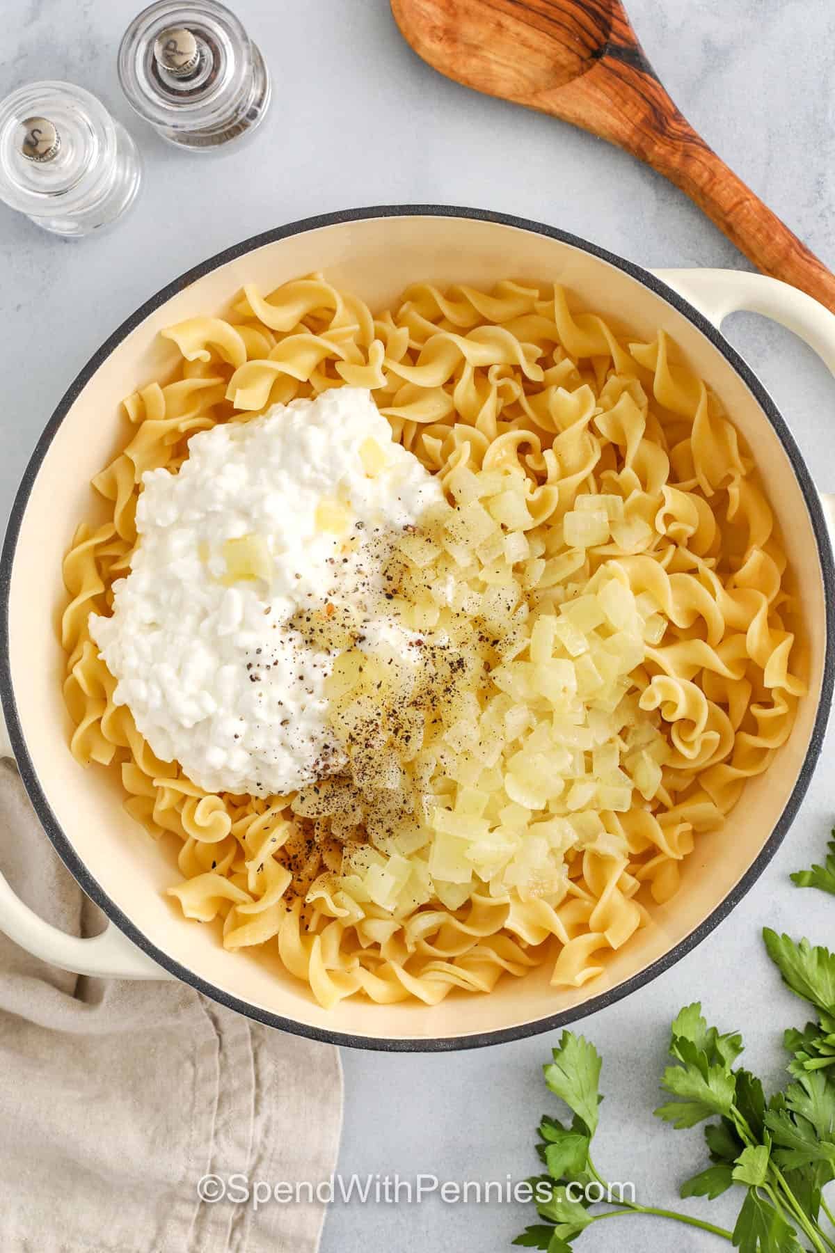 Cottage cheese and noodles are an easy favorite that’s full of flavor and comfort. With creamy cottage cheese, buttery onions, and tender egg noodles, this recipe is smooth, rich, and oh-so-satisfying. It’s a great way to use simple ingredients and still end up with a crowd-pleaser. Pop it in the oven with a crispy topping or enjoy it straight from the skillet. Sour cream is optional, but recommended. #spendwithpennies adding cottage cheese , onions and seasoning to noodles to make Cottage Cheese and Noodles