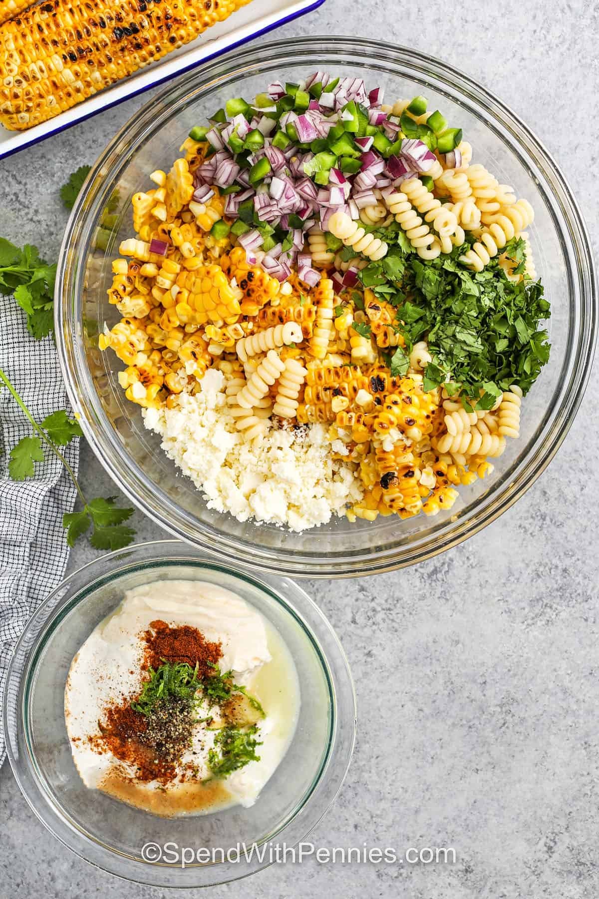 ingredients to make Elote Pasta Salad in a bowl with ingredients to make dressing in a bowl