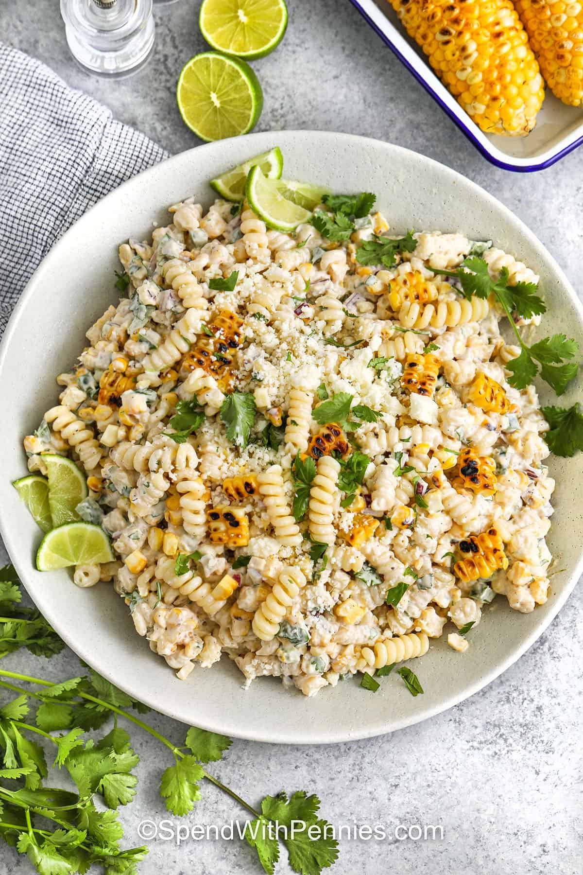 Elote pasta salad turns grilled corn on the cob into a creamy, flavorful pasta dish with a tangy lime and smoked paprika dressing. Cotija cheese adds a salty kick, and jalapeno gives it a subtle heat. Topped with fresh cilantro, this dish is vibrant and refreshing. A great make-ahead salad that’s perfect for backyard cookouts or weekday lunches! #spendwithpennies creamy Elote Pasta Salad in a bowl