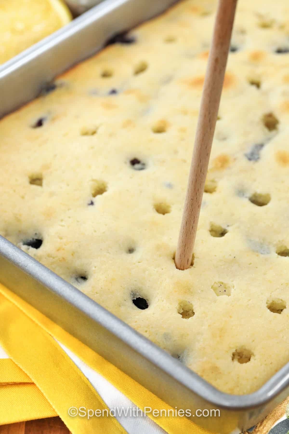 poking holes in Lemon Blueberry Cake