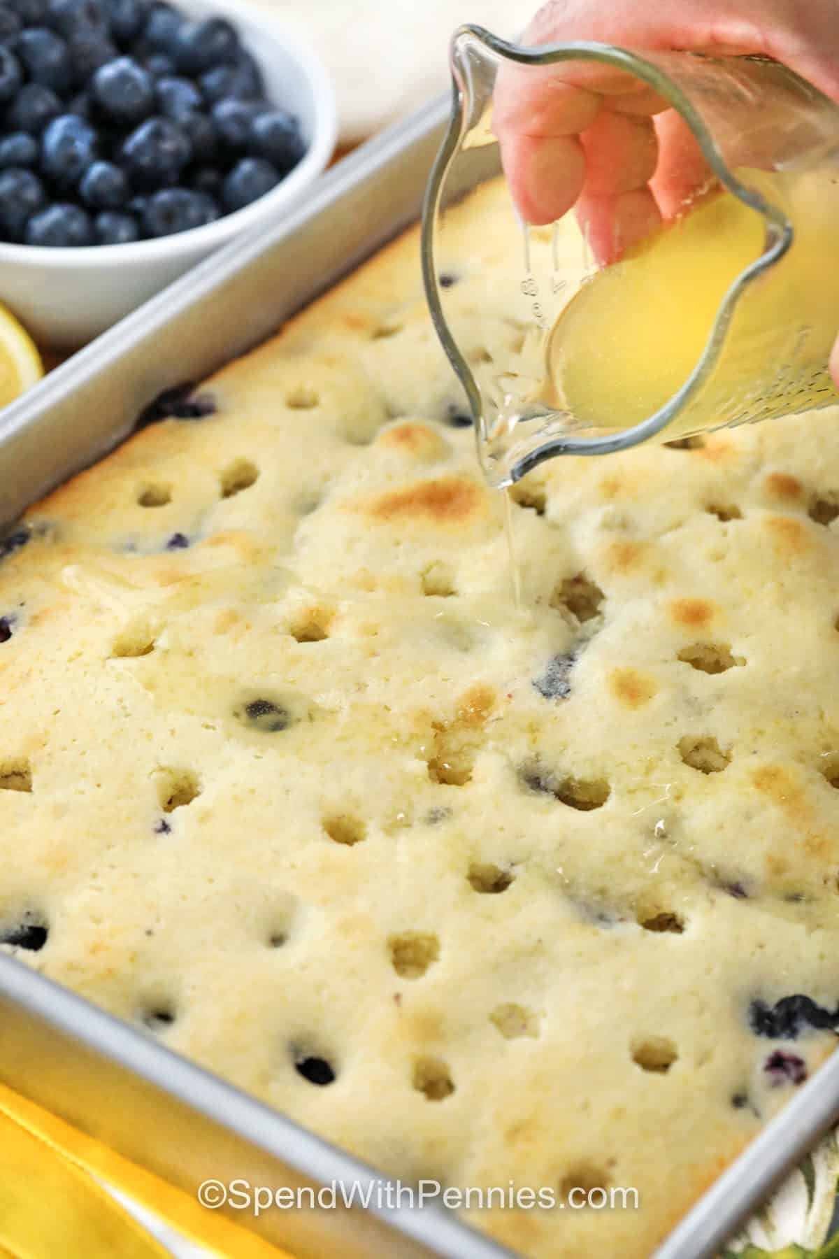 adding sauce over Lemon Blueberry Cake