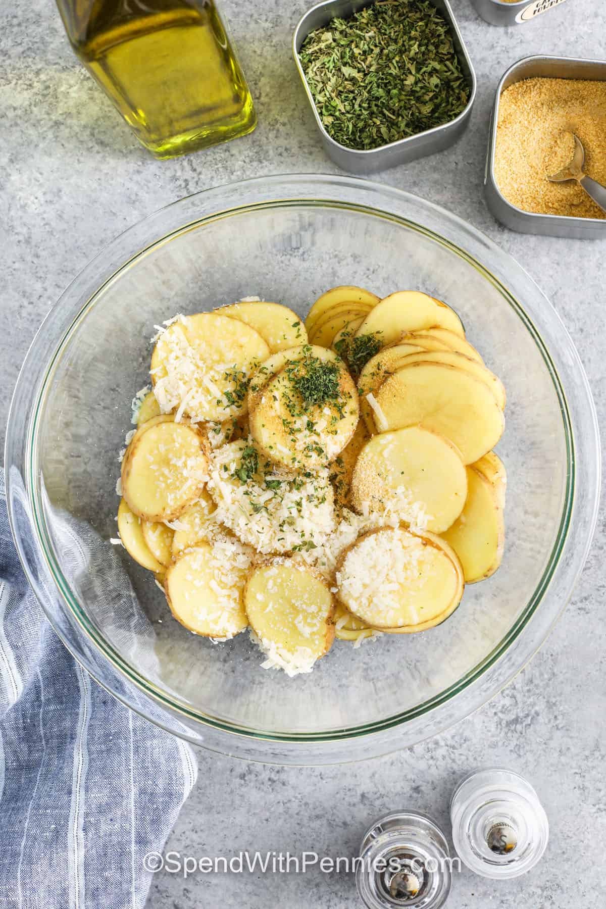 adding seasonings to potato slices to make Oven Baked Potato Slices