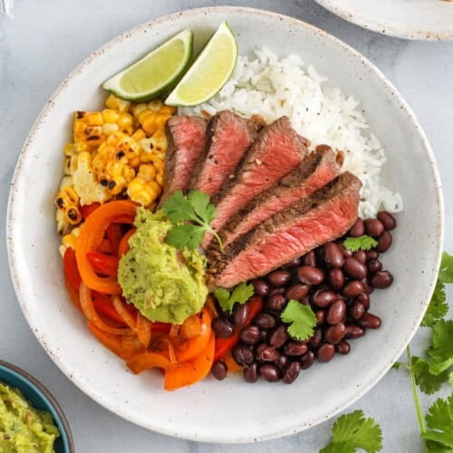 Steak Bowls with rice , beans , corn , peppers and guacamole