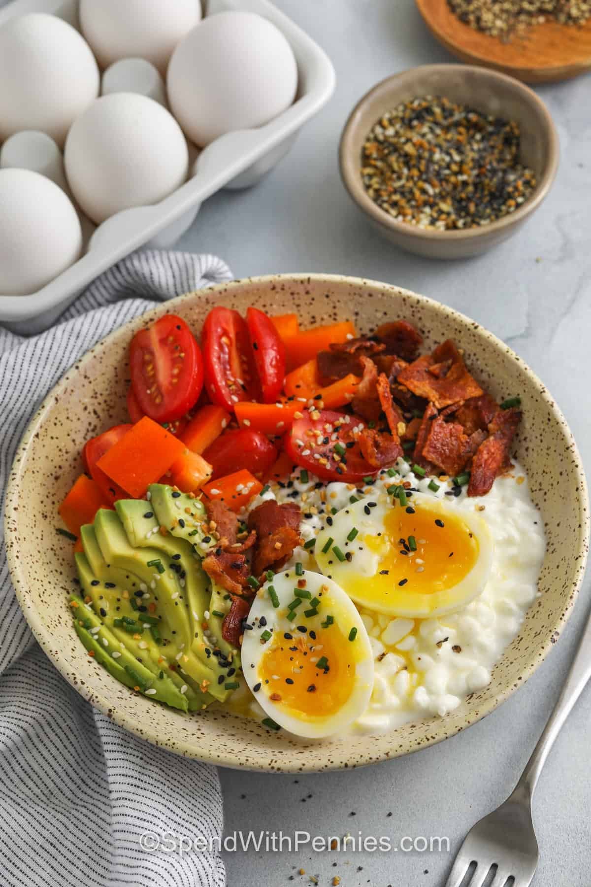 Cottage cheese breakfast bowls are creamy, delicious, and full of wholesome ingredients. Great for a quick breakfast or light snack any time of day. Easy to prepare and endlessly customizable. Nutritious, filling, and packed with flavor in every bite! #spendwithpennies Cottage Cheese Breakfast Bowls with eggs in the back