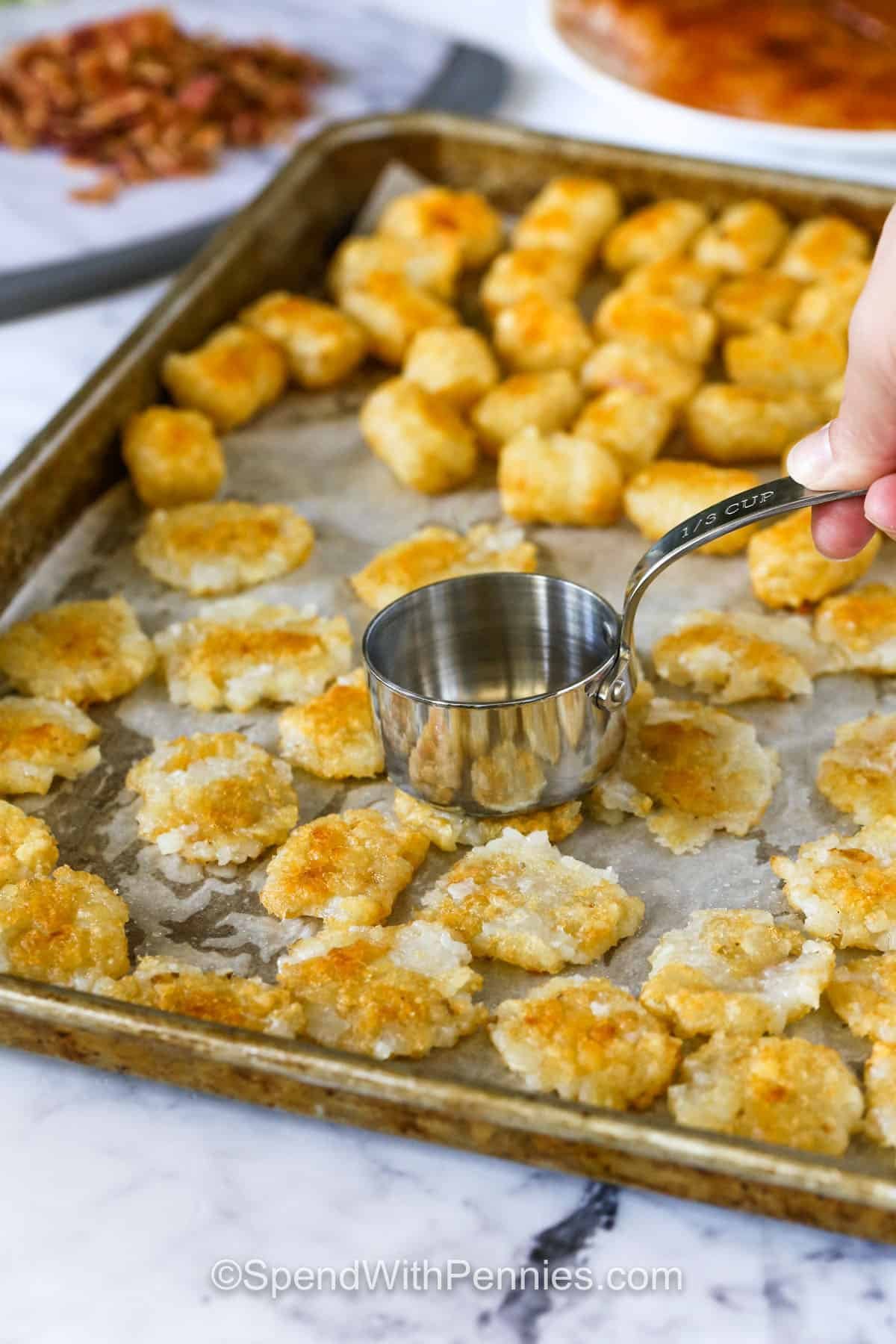 smashing tater tots to make Crispy Tater Caesar Salad
