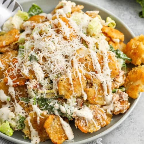 Crispy Tater Caesar Salad in a bowl with dressing