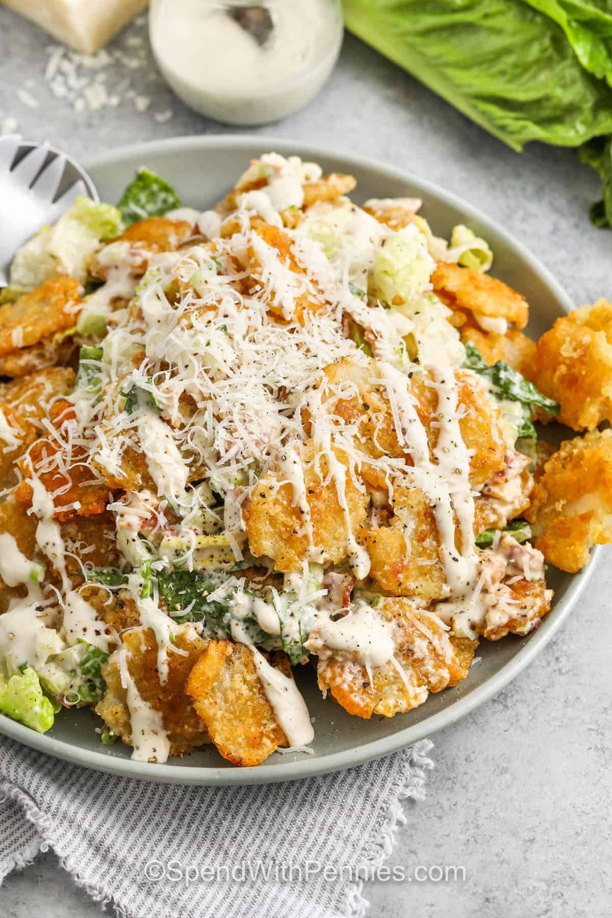 Crispy Tater Caesar Salad in a bowl with dressing