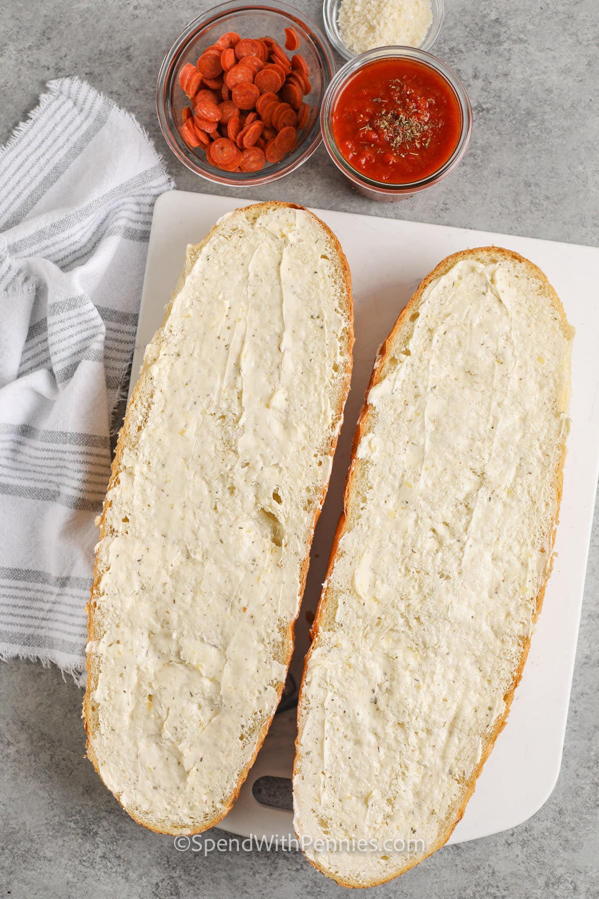adding butter to bread to make French Bread Pizza