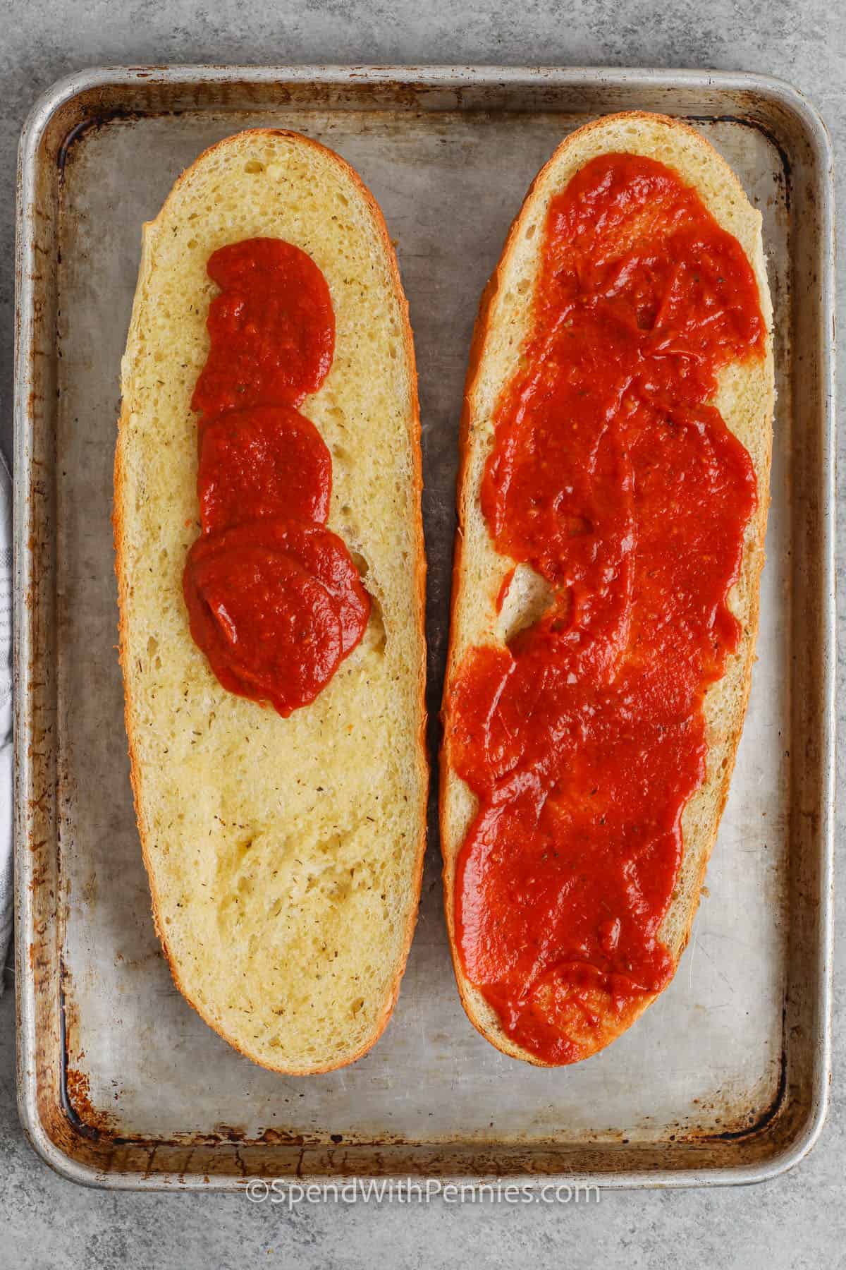 adding tomato sauce to bread loaf to make French Bread Pizza
