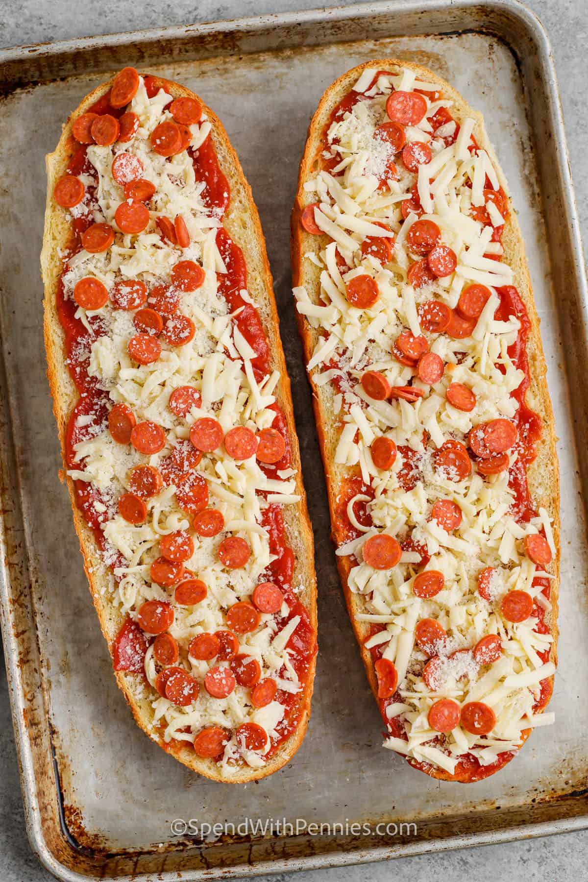 adding cheese and pepperoni to bread to make French Bread Pizza