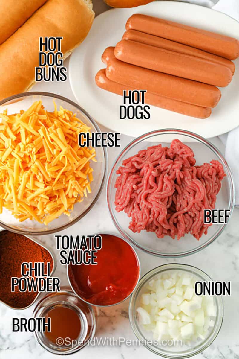 Chili cheese dogs are the ultimate baked treat when you’re craving something warm and cheesy. This hot recipe starts with a buttery bun, a savory dog, rich chili, and gooey cheese on top. It’s the best thing to make when you want comfort food that everyone loves. Make it casserole-style in one dish for easy serving and cleanup. It’s easy to double the recipe if you’re hosting guests. #spendwithpennies hot dog buns , hot dogs , cheese , beef , tomato sauce , chili powder , broth , onion with labels to make Chili Cheese Dogs