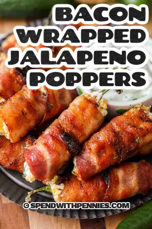 Bacon wrapped jalapeno poppers deliver a perfect blend of smoky bacon, creamy cheese, and spicy jalapeno heat that makes them an irresistible appetizer. The sharp cheddar and garlic powder add layers of flavor, while green onion brings a fresh bite. Easy to prepare and grill or bake, these poppers are ideal for game day, parties, or simple snacking. #spendwithpennies plated Bacon Wrapped Jalapeno Poppers with dip and a title