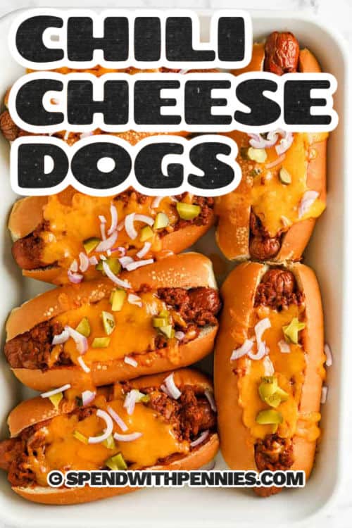 Chili cheese dogs are a hot recipe that always hits the spot, whether it's game day, a movie night, or just because. Juicy hot dogs are baked in buttery top-cut buns, loaded with savory chili, and finished with a gooey blanket of cheddar. This is the best kind of comfort food—simple, hearty, and satisfying. Try turning leftovers into a chili cheese dog casserole for an easy next-day meal. Make a full tray and keep it warm in the oven to serve a crowd. #spendwithpennies Chili Cheese Dogs on a plate with a title