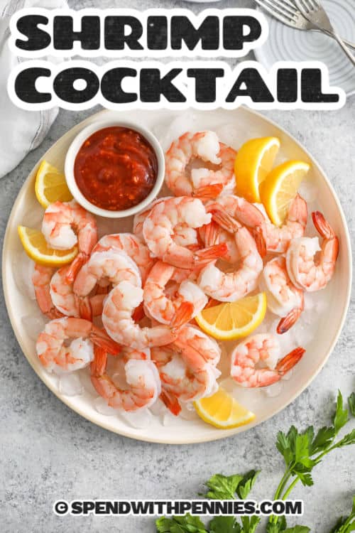 Shrimp cocktail brings bright, zesty flavor and an easy prep with this go-to party recipe. Jumbo shrimp are gently boiled with lemon and herbs, then chilled to keep the texture perfect. They’re served with cocktail sauce for dipping—just the way you want them. Great for holidays or gatherings, this is a classic you’ll want to make again and again. #spendwithpennies Shrimp Cocktail on a plate with lemon slices and a title