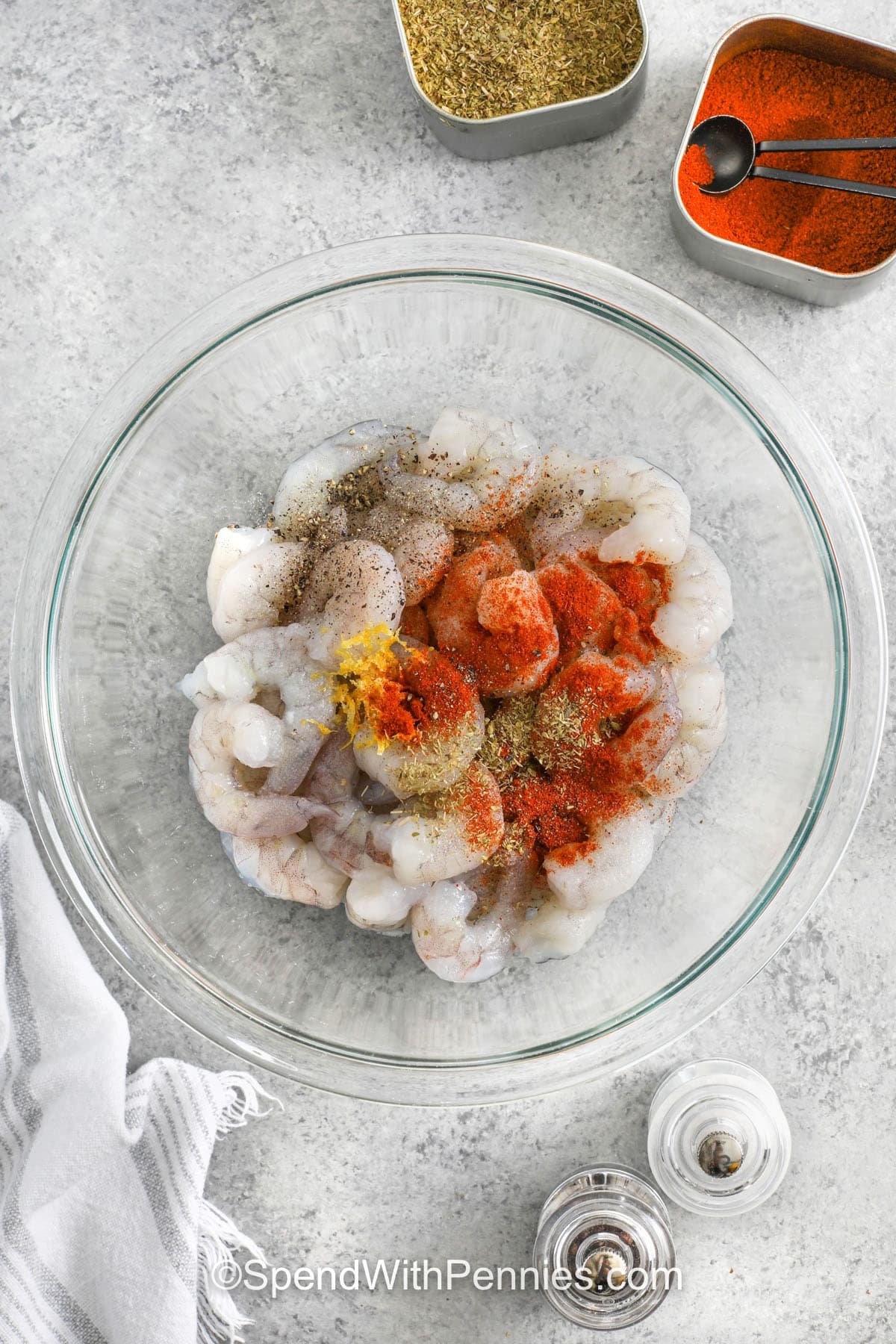 This baked shrimp is full of garlicky goodness and bakes up tender with just a few simple steps. The oven garlic butter seeps into every bite, making it perfect for busy nights or casual get-togethers. With this baked shrimp recipe, you get flavor without the fuss. Serve it with crusty bread or over pasta to soak up every drop. It’s one of those dishes you’ll want to come back to again and again. #spendwithpennies adding seasonings to shrimp to make Oven Baked Shrimp