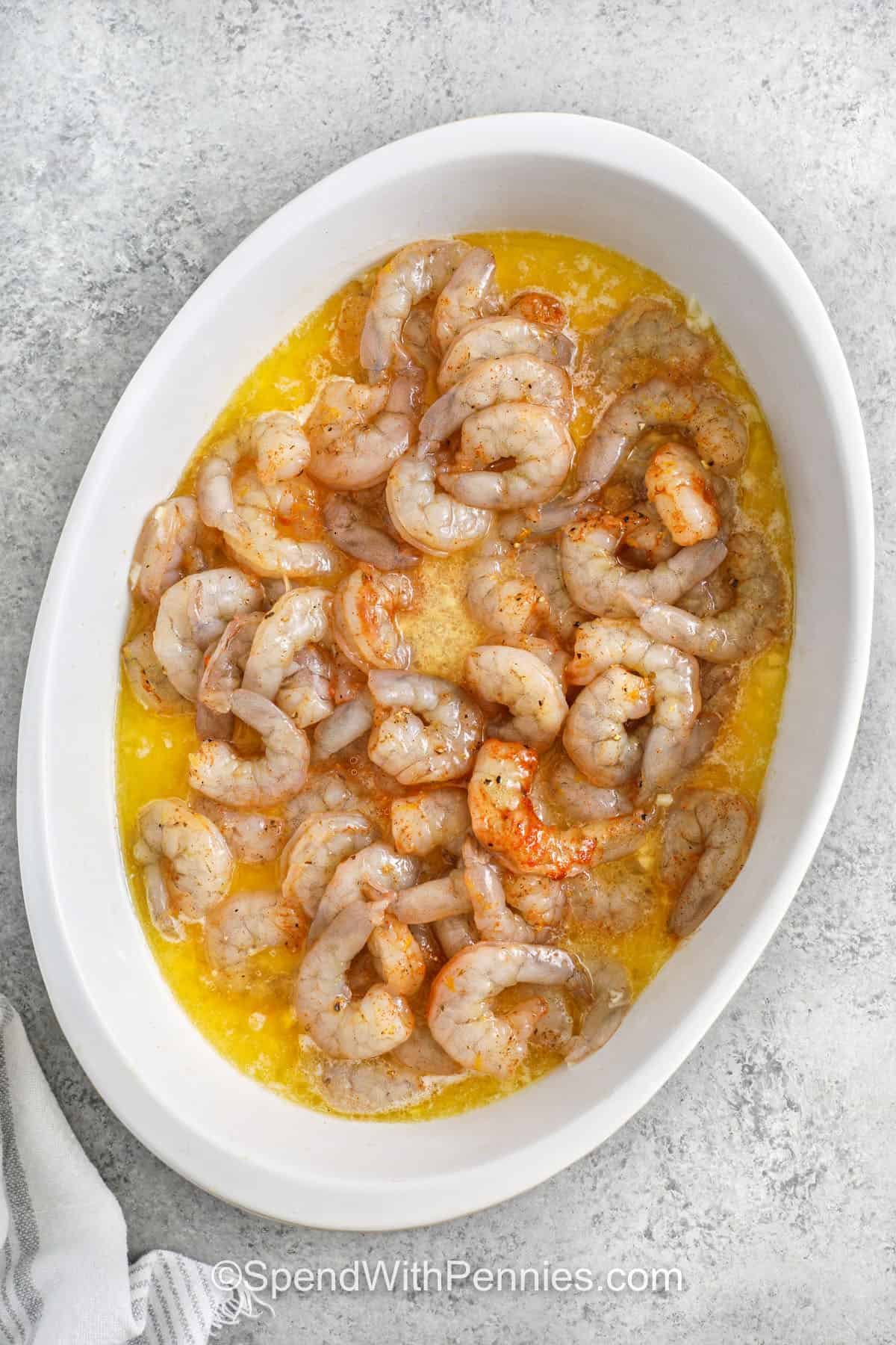 This baked shrimp recipe is loaded with buttery oven garlic flavor and comes out tender every time. It’s one of those go-to recipes that’s easy enough for weeknights but delicious enough for weekends too. This oven baked shrimp recipe works well with bread, rice, or even tucked into tacos. Just a few ingredients and you’ve got a dish the whole table will love. #spendwithpennies adding shrimp to lemon sauce to make Oven Baked Shrimp