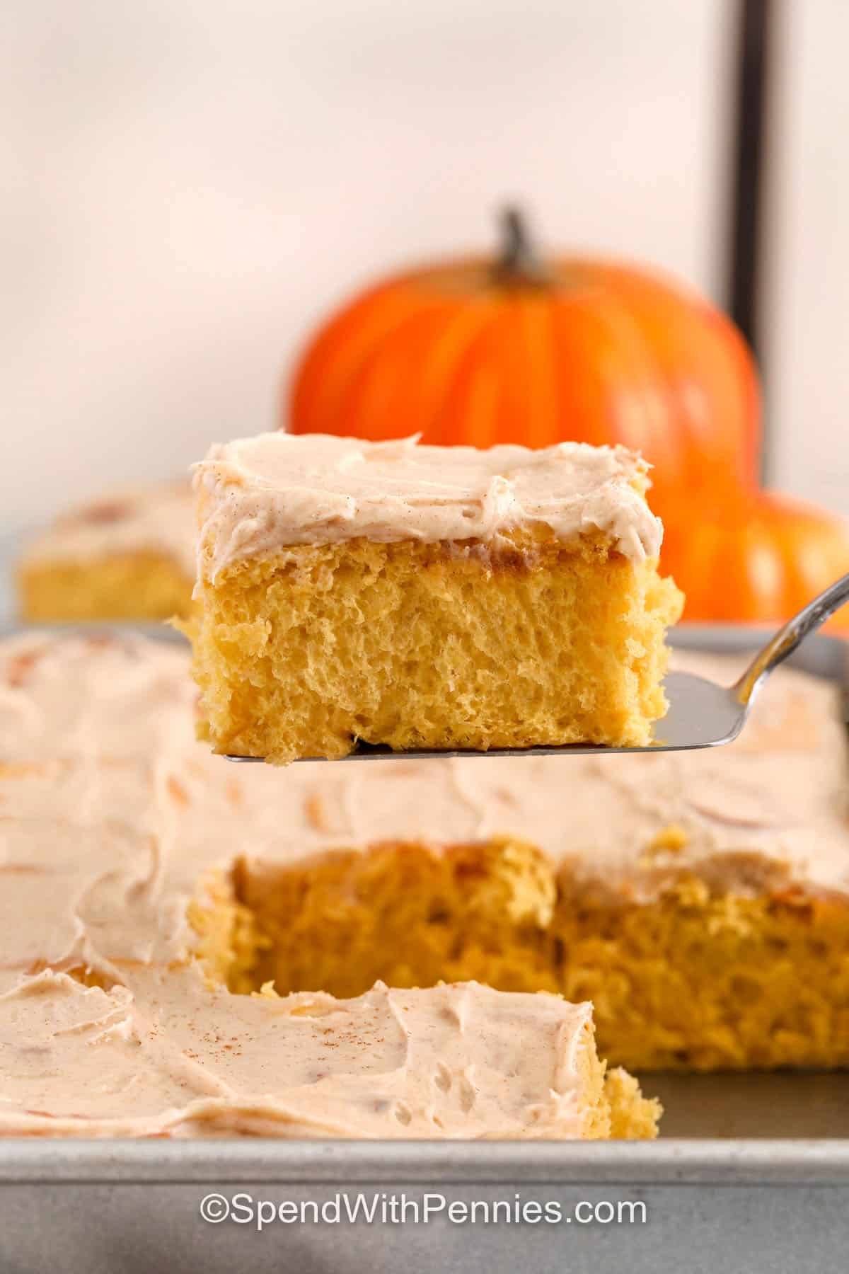 dish full of Pumpkin Cinnamon Rolls with one on a spatula