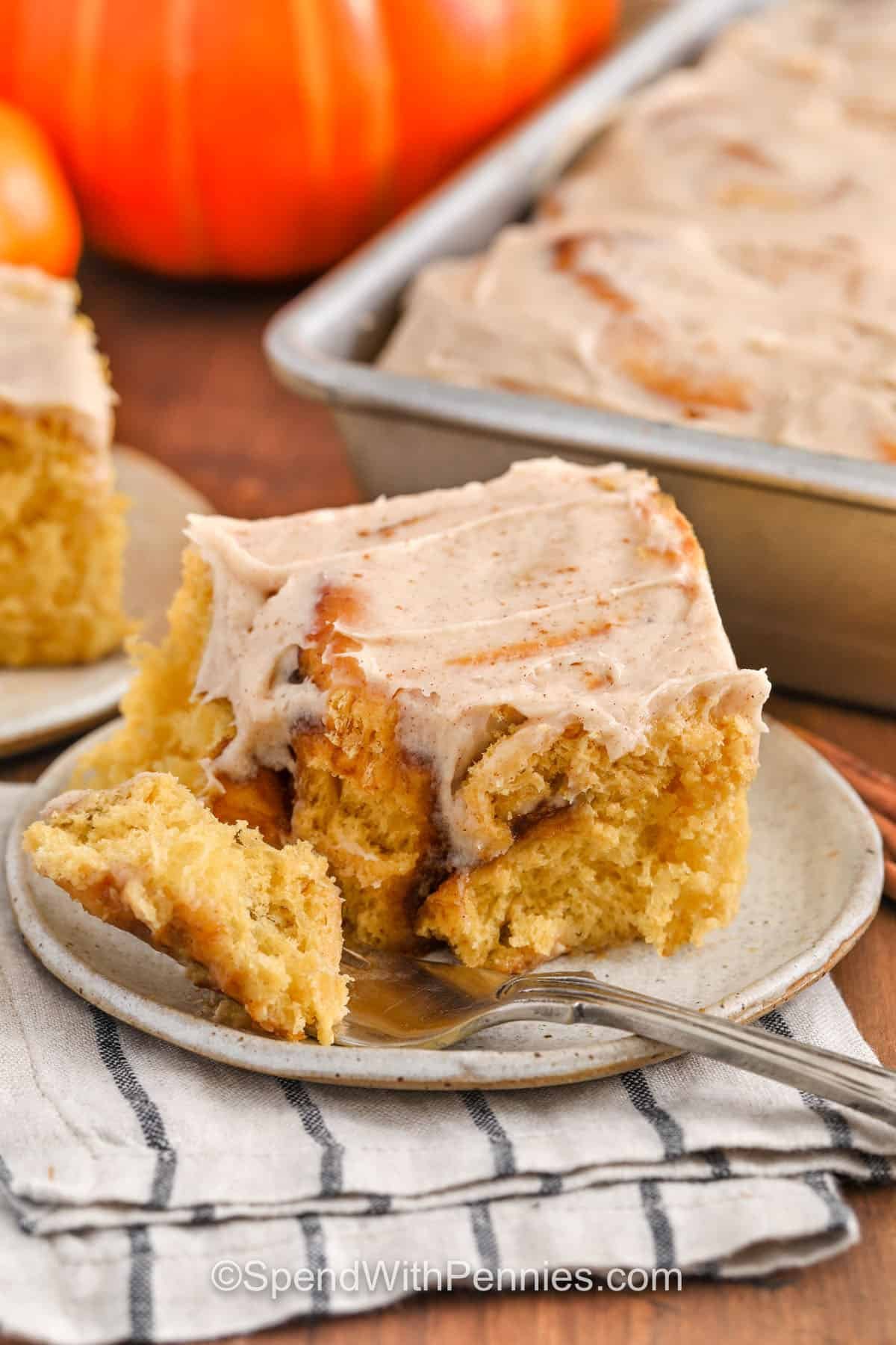 close up of Pumpkin Cinnamon Rolls on a plate with a fork
