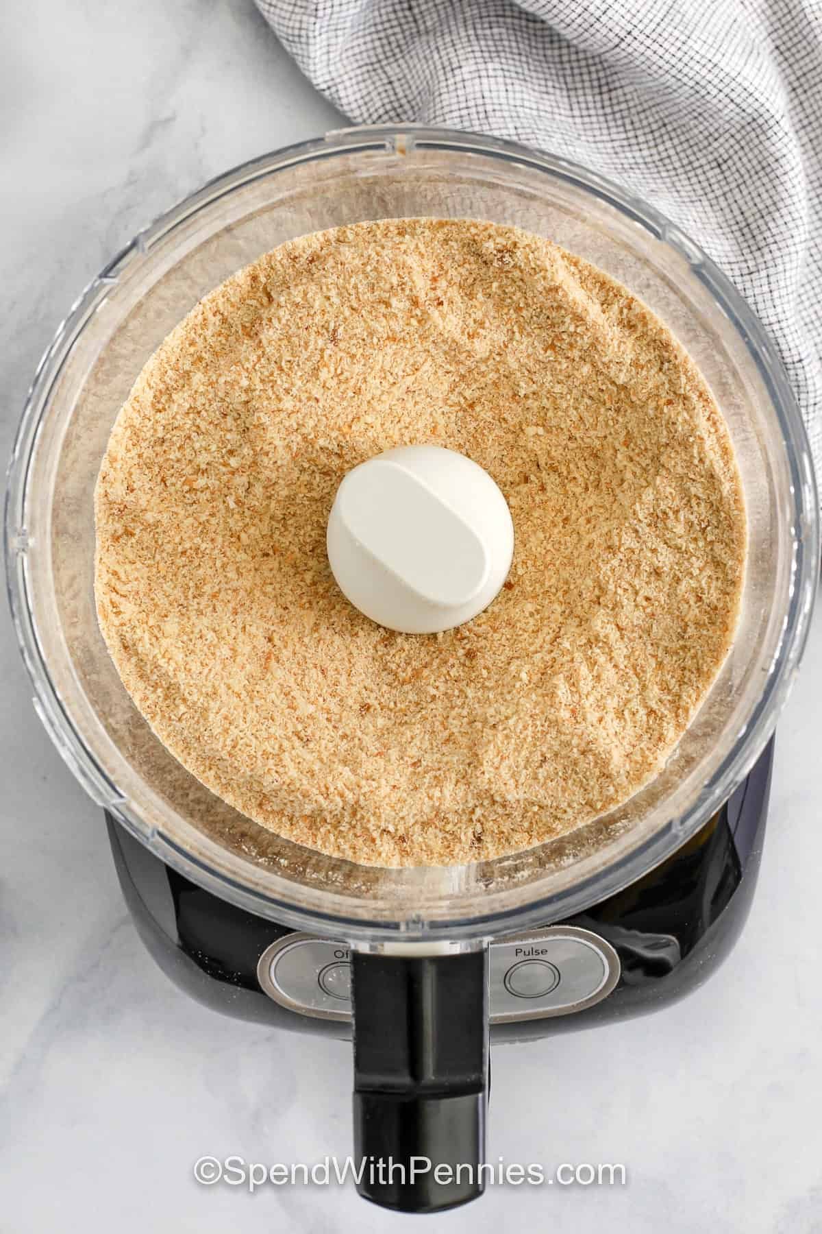 Homemade seasoned bread crumbs are full of flavor and so easy to prepare using pantry spices and dried or fresh bread. Bake stale bread until completely dry and crisp, then blend into fine crumbs and mix with garlic, herbs, and salt. You can use panko or plain crumbs for different textures. No need to buy prepackaged—these taste better and cost less. Keep them on hand for everyday recipes! #spendwithpennies blending bread in a food processor to make Seasoned Bread Crumbs
