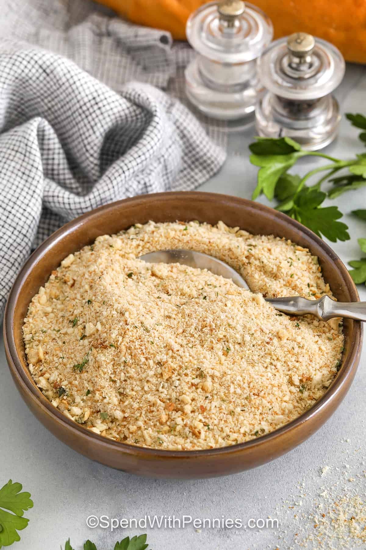 Seasoned bread crumbs are simple to make and packed with classic Italian-style flavor from parsley, garlic, onion, and oregano. Use panko or plain bread crumbs to coat chicken cutlets, top baked pasta, or stir into meatloaf for an easy upgrade. Make a big batch and freeze some for later, you'll be glad you did. It’s a great way to use up stale bread, too! #spendwithpennies wooden bowl full of Seasoned Bread Crumbs