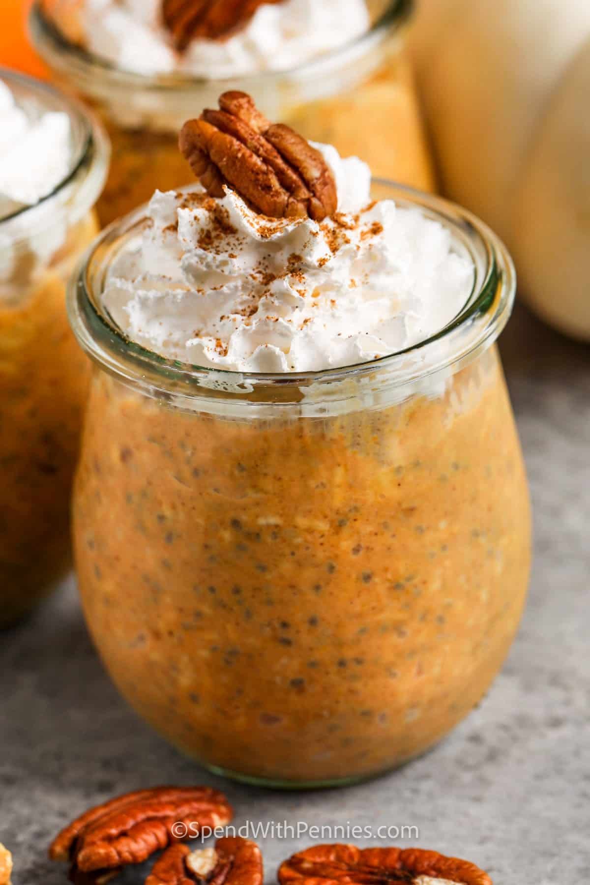 Delicious pumpkin overnight oats are loaded with warm spices and healthy ingredients to keep you energized all morning long. In this easy no-cook recipe, rolled oats are mixed with pumpkin puree, chia seeds, sweetener, and yogurt. Fill some jars and refrigerate overnight for an easy grab-and-go breakfast. Try it with pumpkin pie spices, pecan, and maple syrup for a comforting and wholesome snack or morning meal. Swirl in some almond or peanut butter for variety. #spendwithpennies jar of Pumpkin Overnight Oats