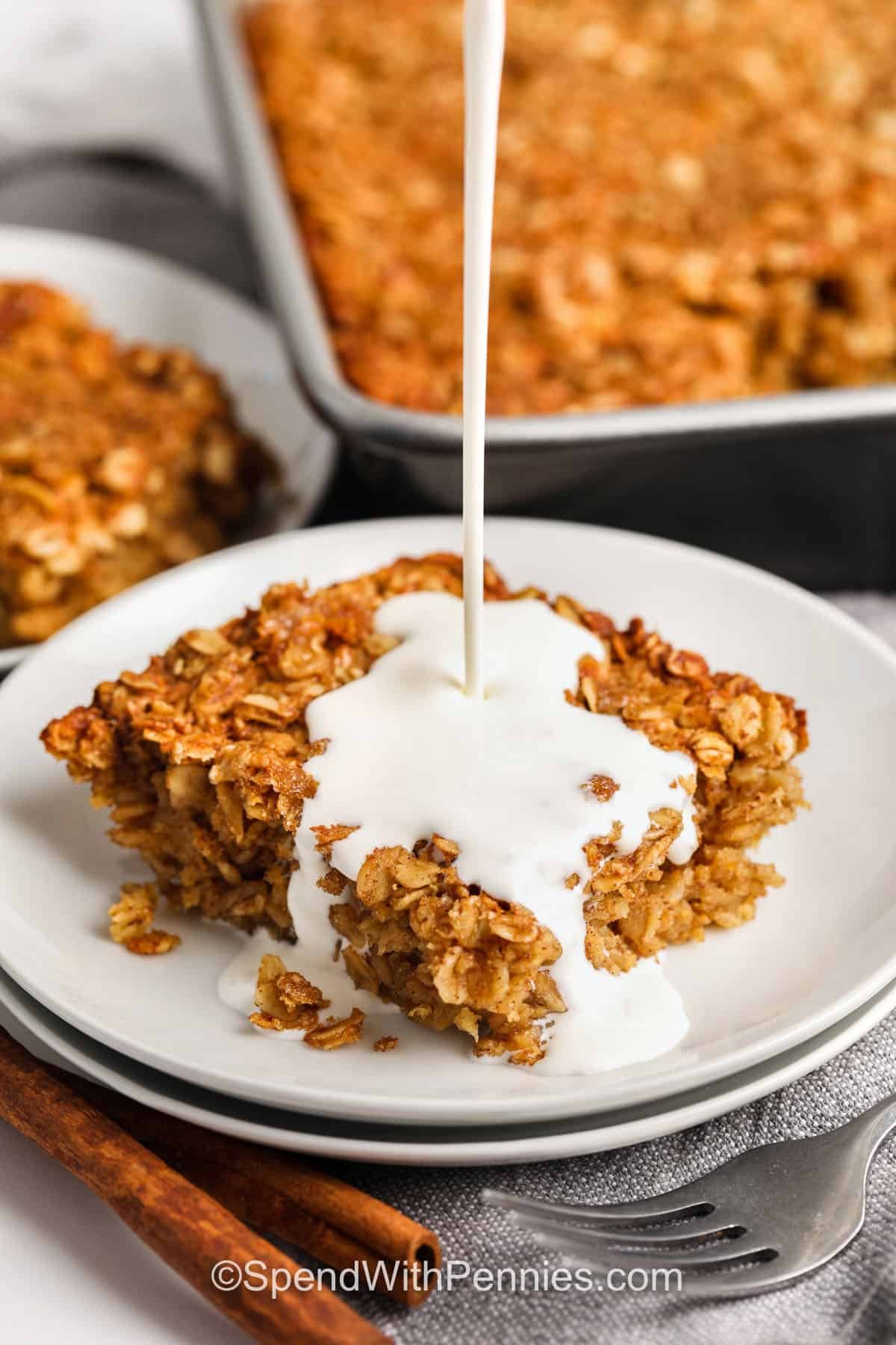 adding cream on top of a piece of Brown Sugar Baked Oatmeal