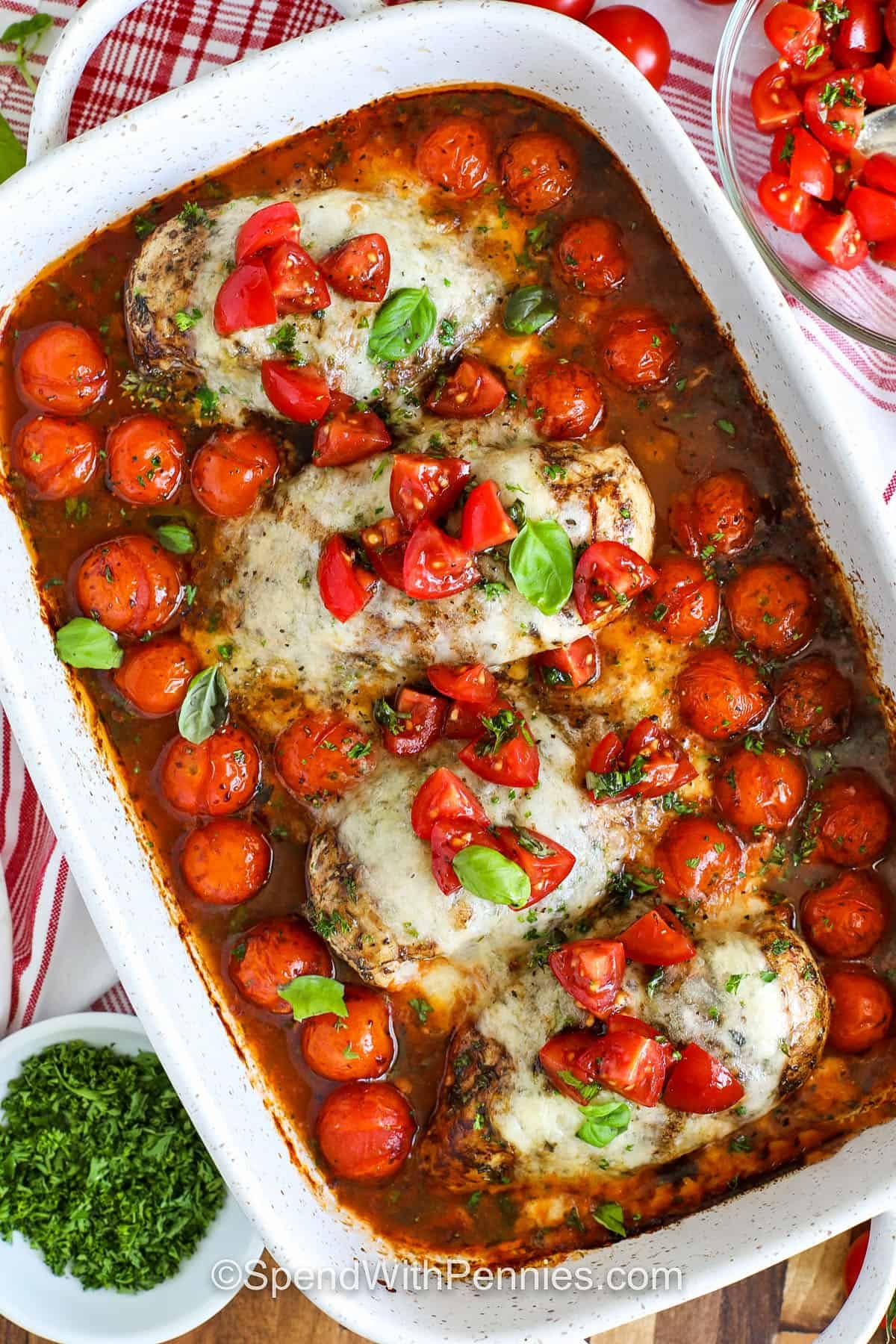 Bruschetta chicken is the perfect baked recipe for a cozy yet elegant dinner. Juicy chicken breast is marinated in balsamic, topped with tomato and mozzarella, then baked until bubbly. A fresh bruschetta topping with basil finishes it beautifully. Pair with pasta, roasted veggies, or salad for a meal that tastes like it's straight from an Italian kitchen. #spendwithpennies casserole dish of hot Bruschetta Chicken