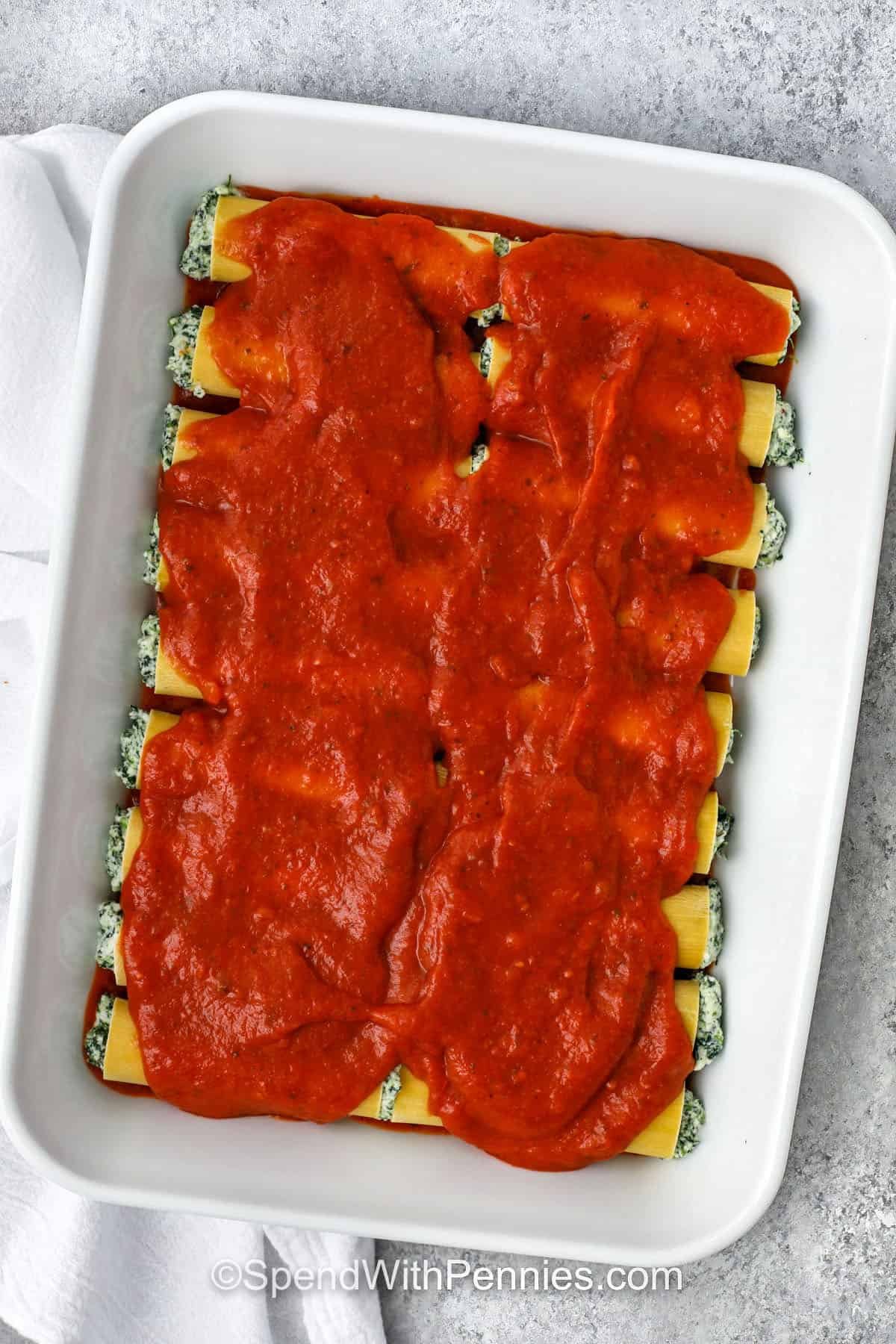 adding pasta sauce on top of Cheese Cannelloni before cooking